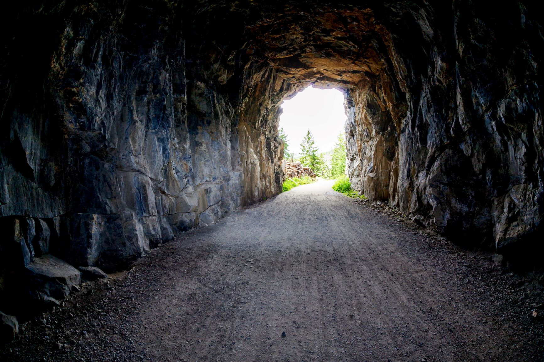 Rock and gravel tunnel, light at the end with nature scene, new normal