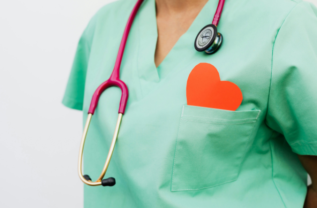healthcare worker with a paper heart in their breast pocket, stethoscope around neck