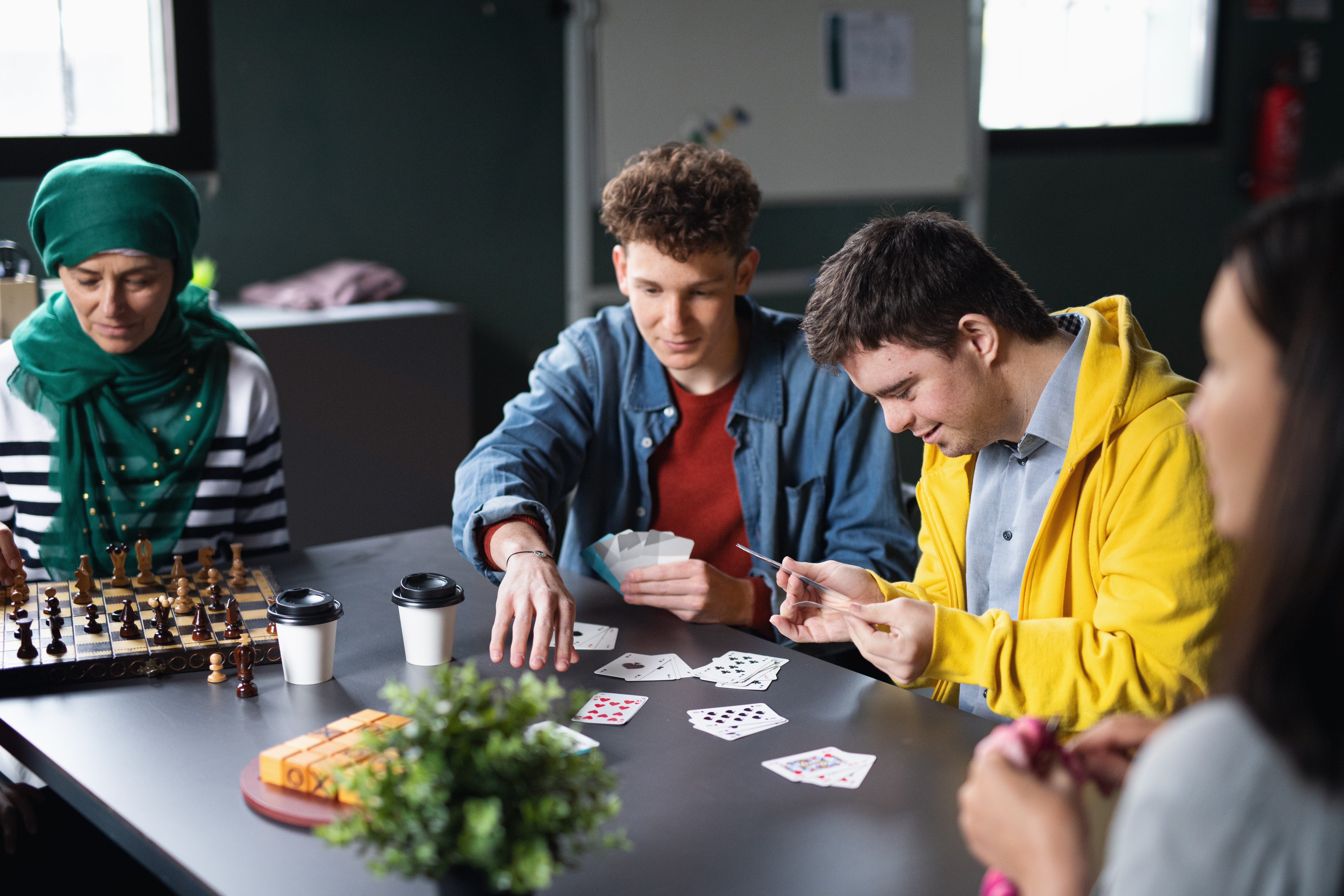 group of people playing games in community including disabled person in a yellow jacket